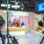 Photo of video recording equipment and stage in a studio during the filming of a TV show.